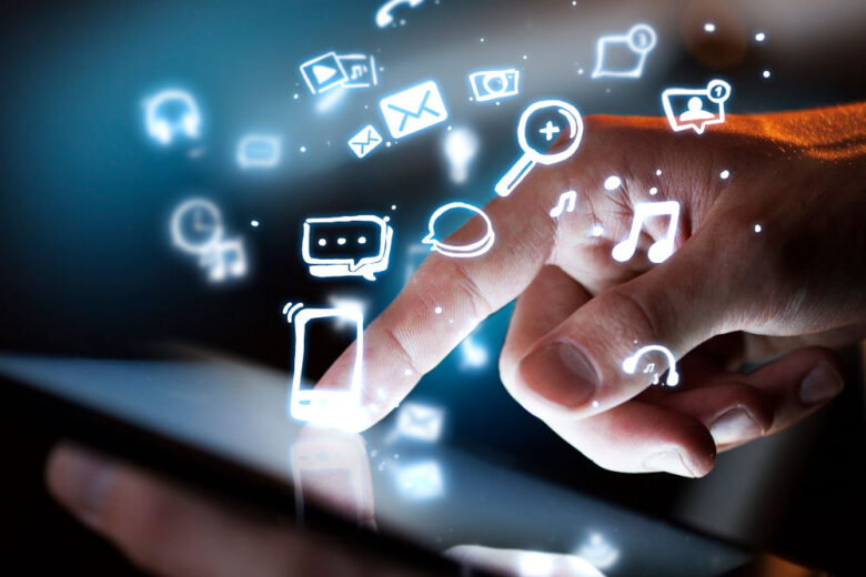 Finger touching tablet with digital icons.